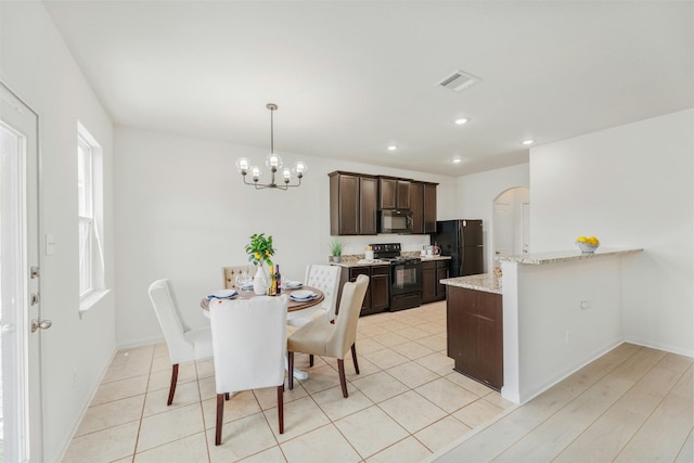 tiled dining area featuring a chandelier