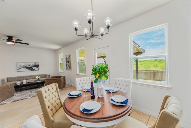 dining space featuring tile patterned floors, ceiling fan with notable chandelier, and a healthy amount of sunlight