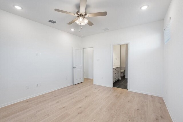 unfurnished bedroom featuring ceiling fan, connected bathroom, and light wood-type flooring