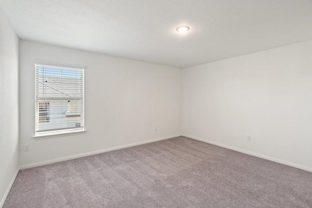 carpeted empty room with a textured ceiling