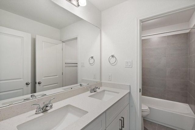 full bathroom featuring tiled shower / bath, vanity, toilet, and tile patterned flooring