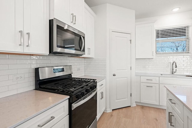 kitchen featuring white cabinetry, sink, decorative backsplash, and appliances with stainless steel finishes