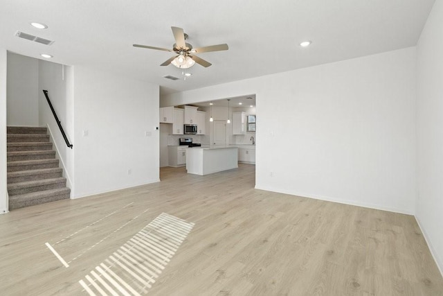 unfurnished living room with ceiling fan and light hardwood / wood-style flooring