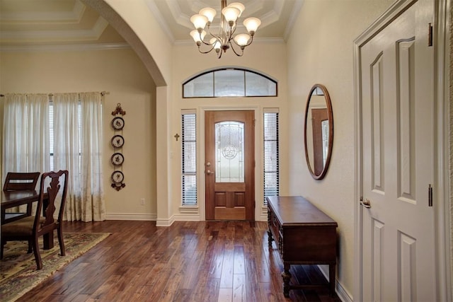 foyer with a chandelier, dark hardwood / wood-style flooring, a tray ceiling, and crown molding