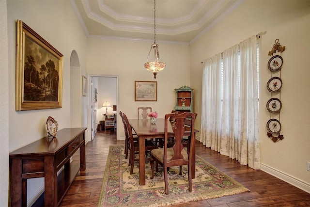 dining room with dark wood-type flooring, crown molding, and a tray ceiling