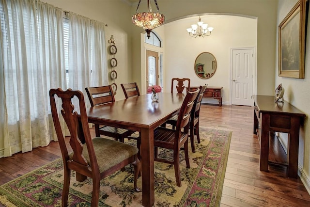 dining space featuring hardwood / wood-style floors and a chandelier