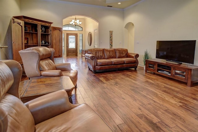 living room with hardwood / wood-style floors, crown molding, and a notable chandelier