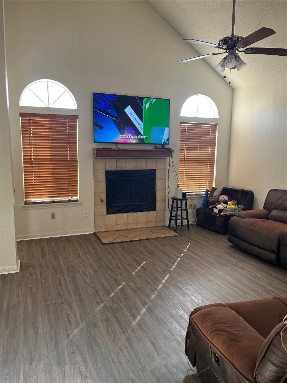 living room with a tile fireplace, hardwood / wood-style floors, plenty of natural light, and ceiling fan