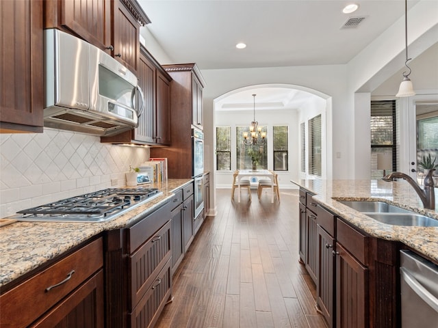 kitchen with a chandelier, sink, hanging light fixtures, and appliances with stainless steel finishes