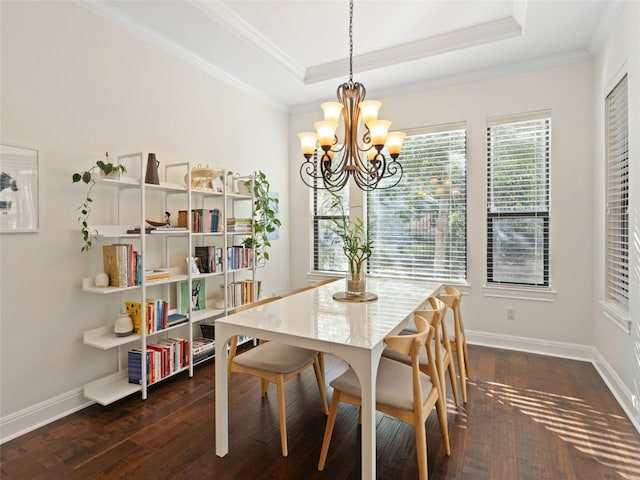 dining room featuring a raised ceiling, dark wood-type flooring, and an inviting chandelier