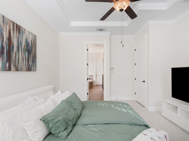 bedroom with ceiling fan, carpet floors, crown molding, and a tray ceiling