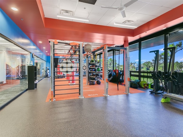 exercise room featuring a paneled ceiling and ceiling fan