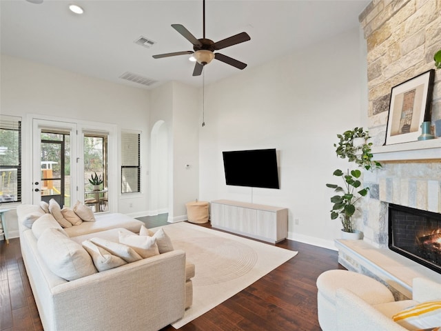 living room featuring a fireplace, dark hardwood / wood-style floors, and ceiling fan