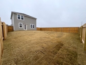 back of house with a fenced backyard