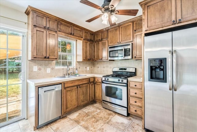 kitchen featuring ceiling fan, appliances with stainless steel finishes, sink, and backsplash