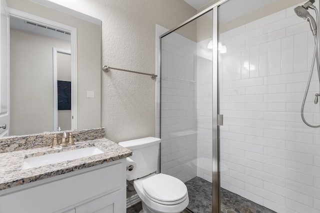 bathroom with vanity, an enclosed shower, and toilet