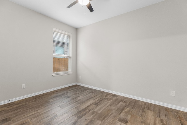 spare room with dark hardwood / wood-style flooring and ceiling fan