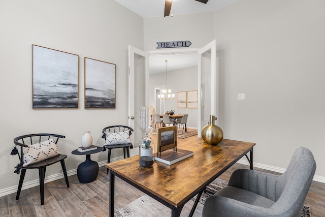 home office featuring ceiling fan with notable chandelier and hardwood / wood-style flooring