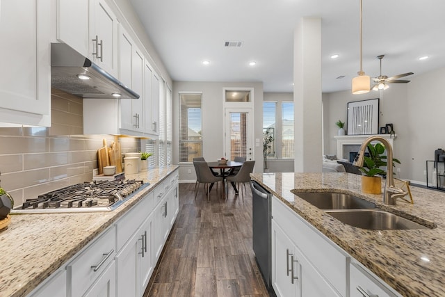 kitchen featuring appliances with stainless steel finishes, dark hardwood / wood-style flooring, ceiling fan, sink, and white cabinetry