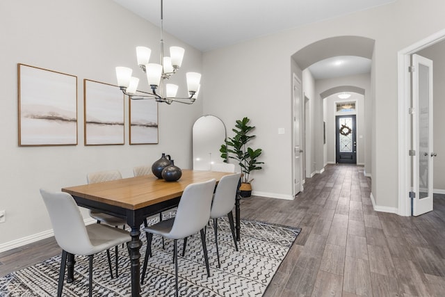 dining area with a notable chandelier and dark hardwood / wood-style flooring