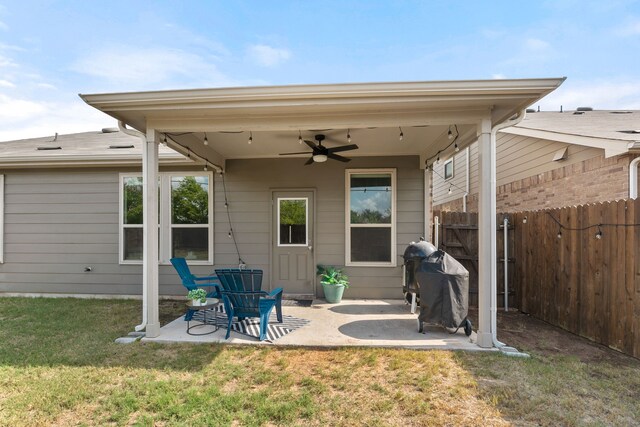 back of property featuring ceiling fan, a patio area, and a lawn