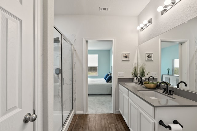 bathroom featuring wood-type flooring, vanity, and a shower with shower door