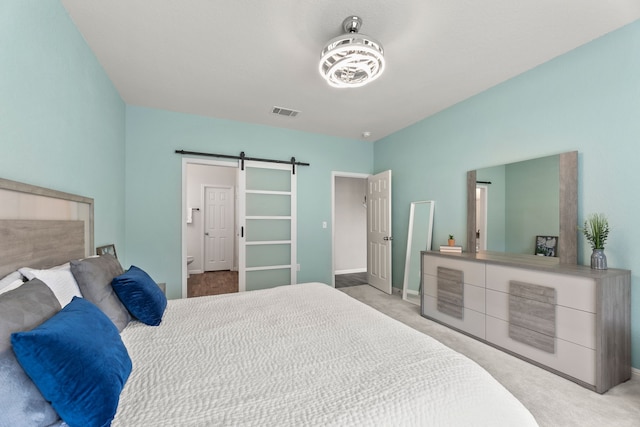 carpeted bedroom with a barn door