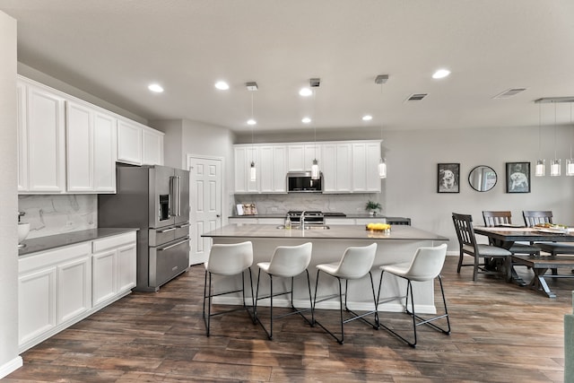 kitchen featuring white cabinetry, stainless steel appliances, decorative light fixtures, and decorative backsplash