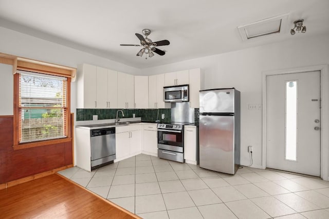 kitchen with backsplash, white cabinets, ceiling fan, plenty of natural light, and stainless steel appliances