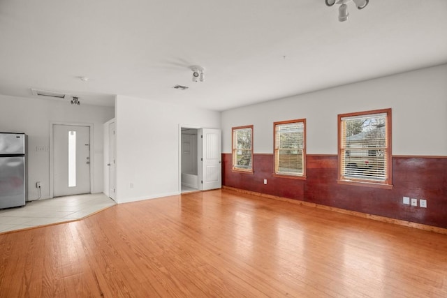 unfurnished living room featuring light hardwood / wood-style flooring and plenty of natural light