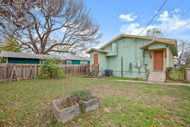 back of property featuring cooling unit and a lawn