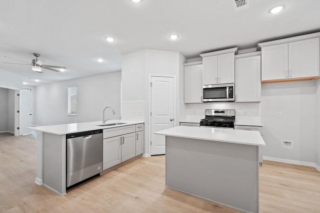 kitchen with sink, light hardwood / wood-style flooring, ceiling fan, white cabinetry, and stainless steel appliances