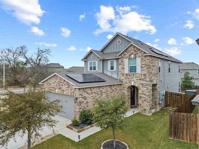 view of front of property with solar panels, a garage, and a front lawn