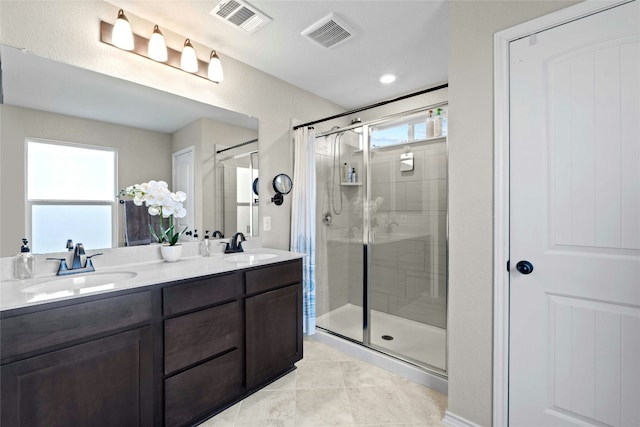 bathroom with a wealth of natural light, vanity, and a shower with shower door