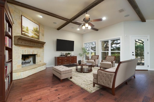 604 Hannahs Run, New Braunfels, TX 78130 - living room with beamed ceiling, ceiling fan, dark wood-type flooring, healthy amount of natural light, and a stone fireplace