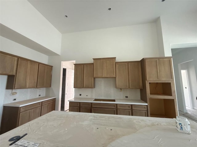 1748 Snowdrop Dr, Georgetown, TX 78628 - kitchen featuring backsplash, brown cabinets, and a high ceiling