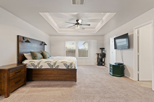 bedroom with light carpet, a tray ceiling, and ceiling fan