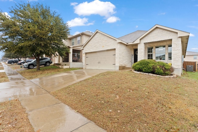 view of front facade featuring a garage, a front yard, and central AC