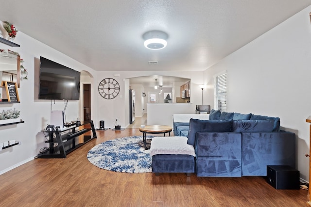 living room with a textured ceiling and hardwood / wood-style flooring