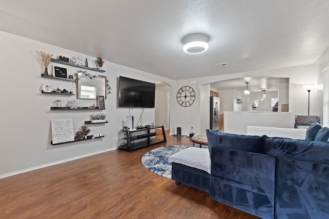 living room with wood-type flooring and a textured ceiling