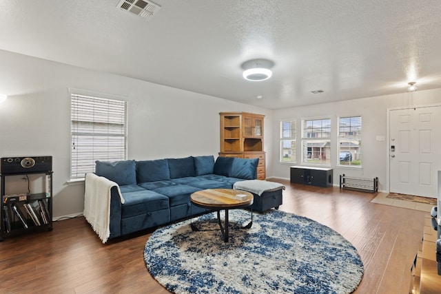 living room featuring a textured ceiling and dark wood-type flooring