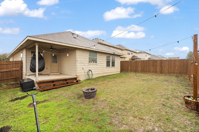 back of house with a wooden deck, ceiling fan, and a yard