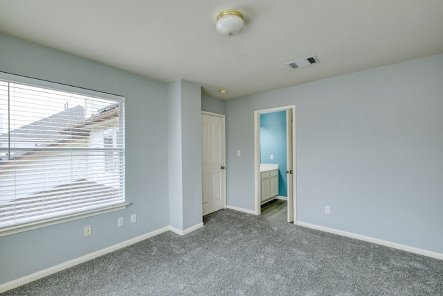 unfurnished bedroom with connected bathroom and light colored carpet