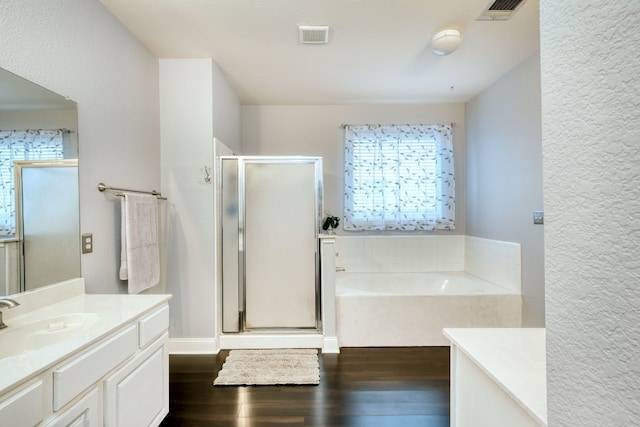 bathroom featuring hardwood / wood-style floors, vanity, a wealth of natural light, and independent shower and bath