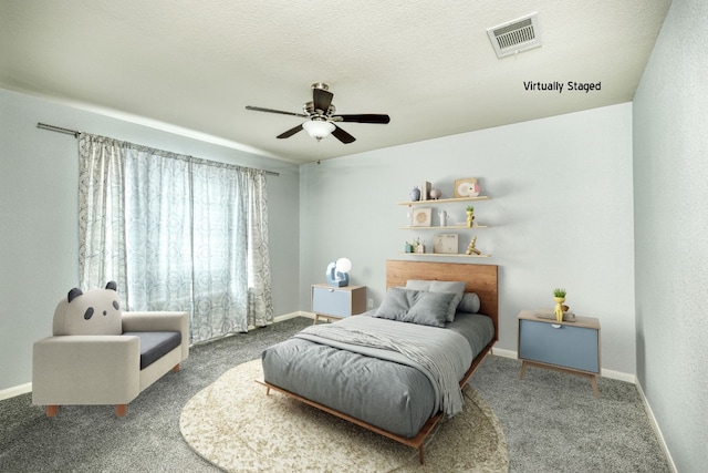 carpeted bedroom with ceiling fan and a textured ceiling