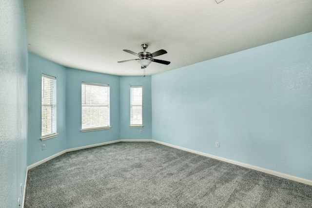 carpeted spare room featuring plenty of natural light and ceiling fan