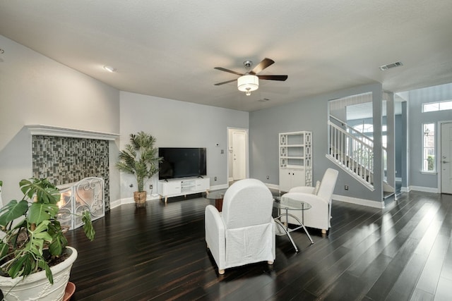 living room featuring ceiling fan and dark hardwood / wood-style flooring