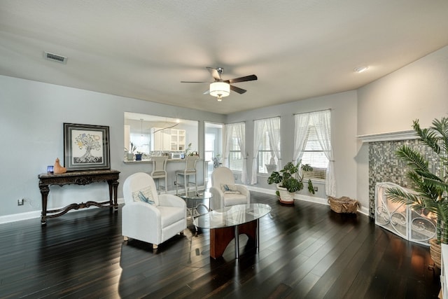 living area featuring ceiling fan and dark hardwood / wood-style floors