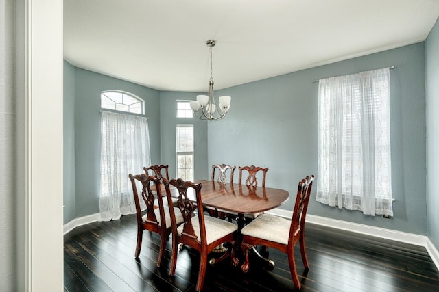 dining area with dark hardwood / wood-style floors and a chandelier