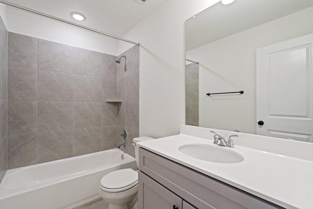 full bathroom with toilet, vanity, and tiled shower / bath